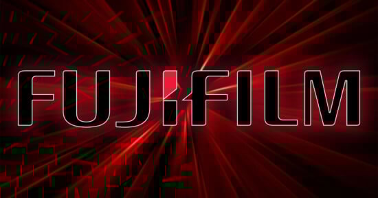 A glowing red background with the bold, uppercase text "FUJIFILM" displayed prominently in black with white outlines. A stylized design in white and red is used for the "J" in "FUJIFILM". Radiating lines give a dynamic effect to the background.